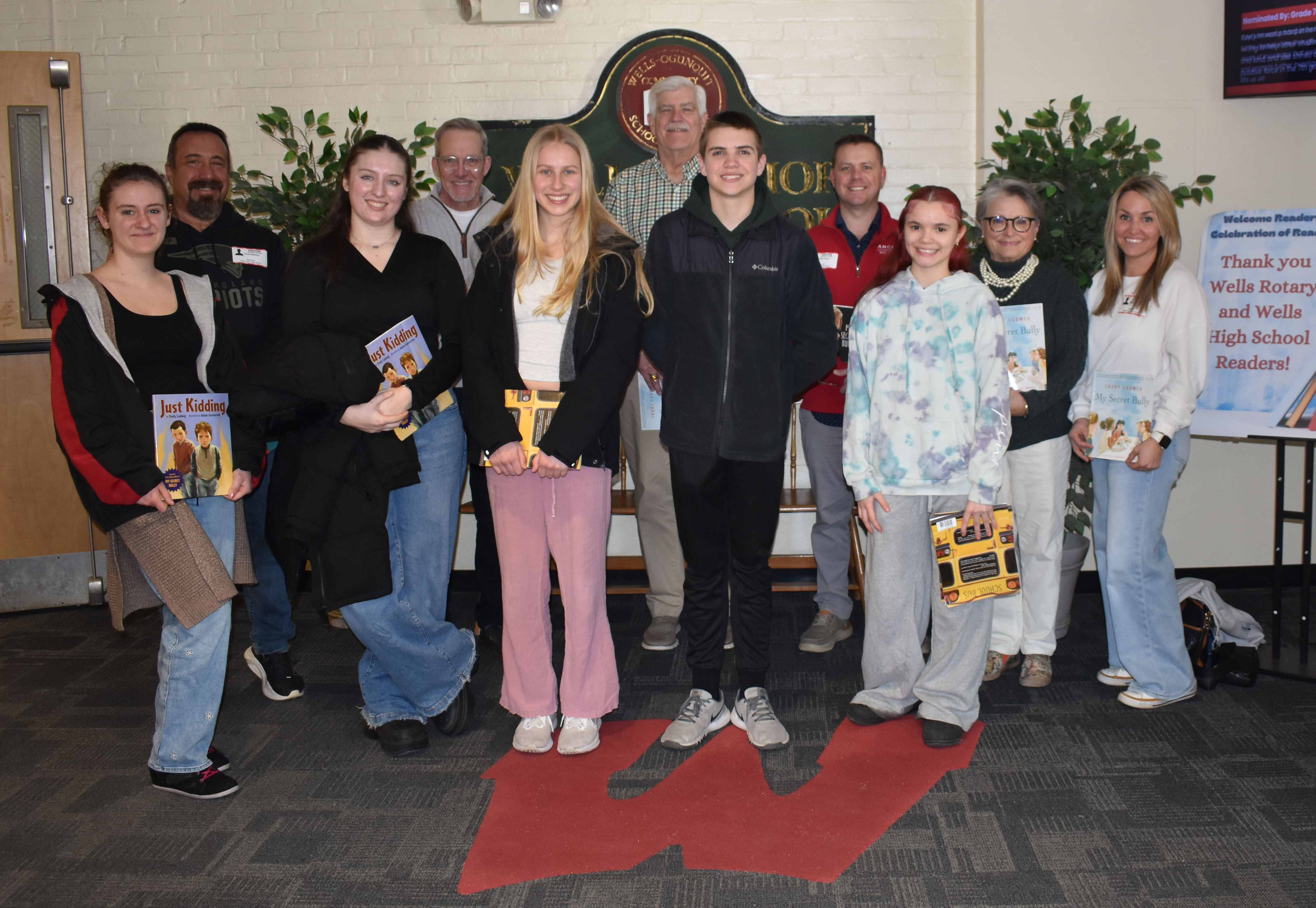 In the photo (back row, left to right ) are Wells Rotary Club members: Scott DeFelice, Peter Bolton, Bob Foley, Nate Mayo, Lisa Roderick, and Melissa Busickand. WHS students (front row, left to right) are Nora Ferris, Alivia Collin, Isla Collins, Noah Busick, and Amarie Colon. This group visited classrooms in the 5th-grade area of WJHS to read to students on March 13, 2026